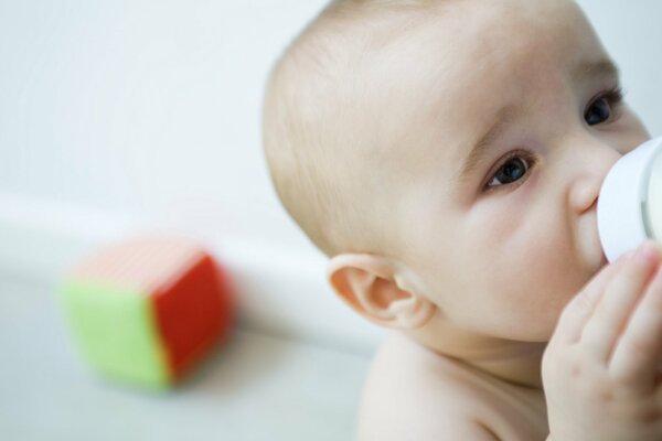 Bebe leche de un biberón