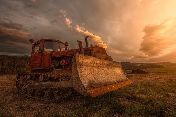 Bulldozer en el campo en medio de un cielo formidable