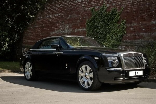 Rolls-royce negro contra una vieja pared de color Burdeos