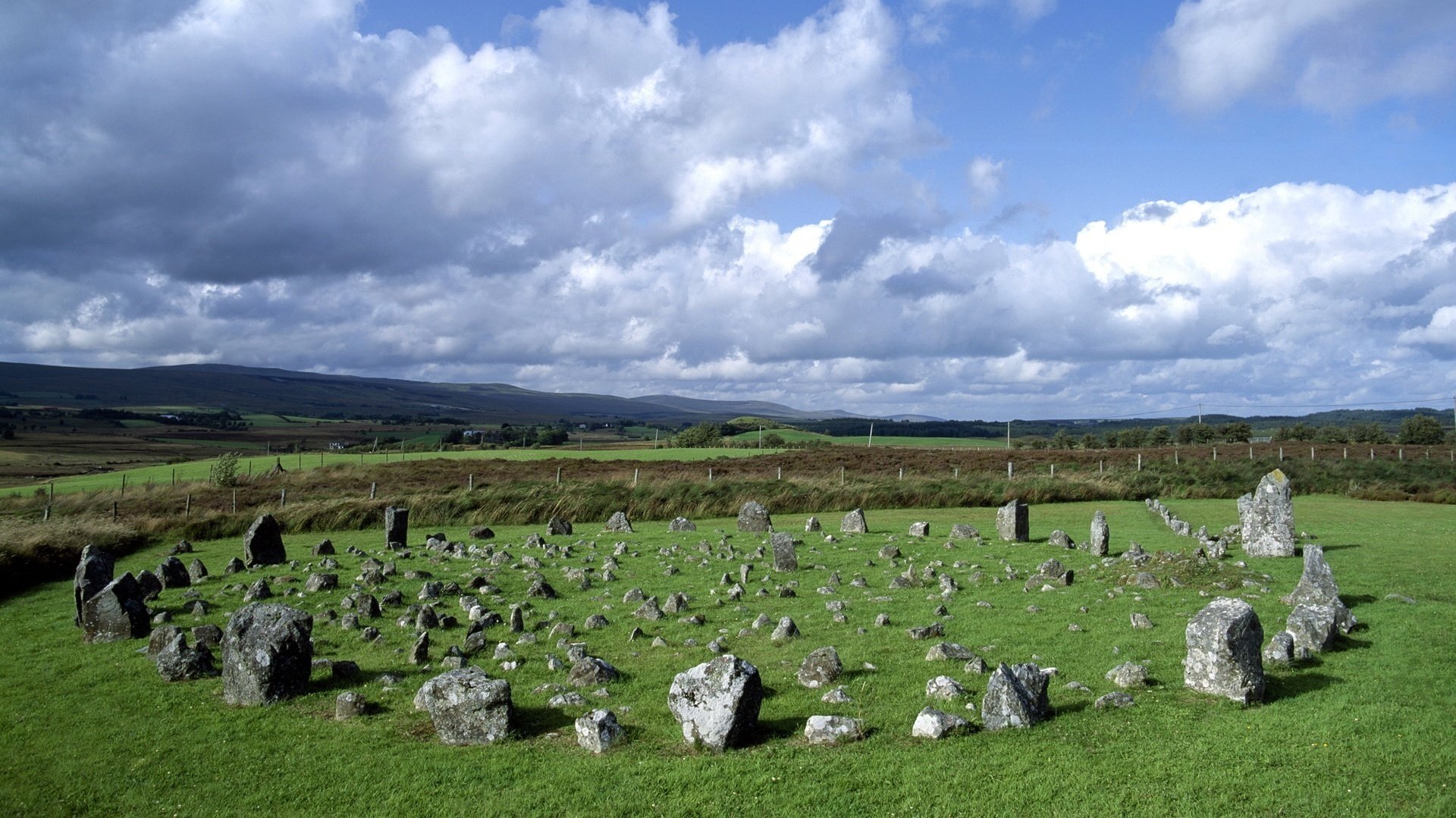 círculo de piedra trozos de piedra claro cielo nubes círculo cerca naturaleza vegetación verano prado