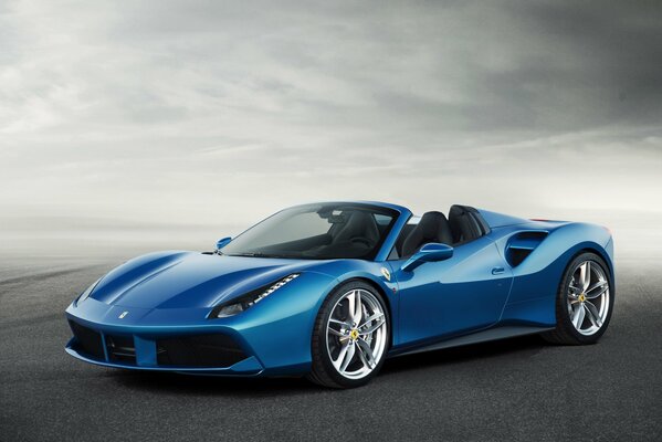 Ferrari de carreras azul en la carretera en la niebla