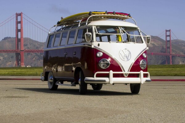 Autobús rojo y blanco en el fondo del famoso puente Golden Gate. Lindo autobús brillante marca Volkswagen