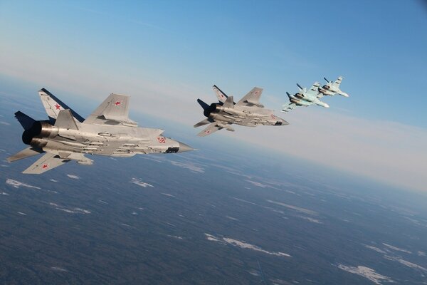 Aviones de combate volando en el cielo sobre la tierra