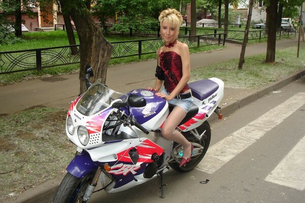 Mujer en minifalda en una motocicleta en la carretera