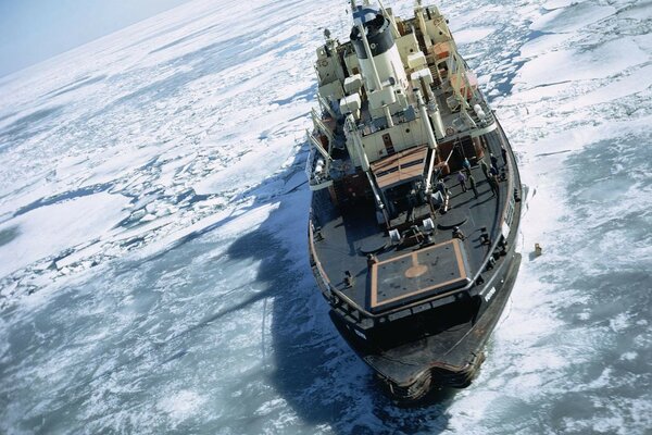 Barco en el Ártico en un témpano de hielo entre el agua