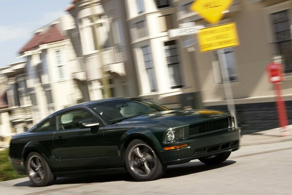 Un Ford Mustang oscuro dentro de la ciudad