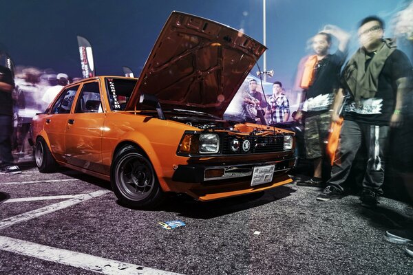 Naranja Toyota Corolla. Personas en movimiento