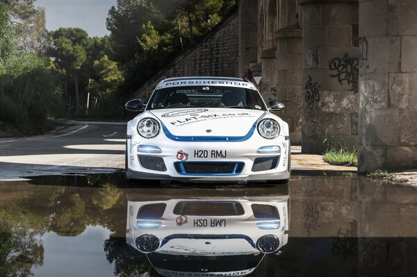 El Porsche blanco se refleja en el elegante espejo de agua