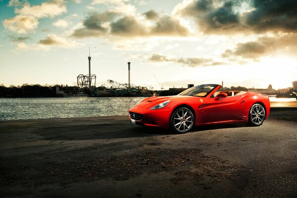 Coche Ferrari California en el muelle junto al río