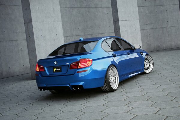 BMW azul en la pared gris