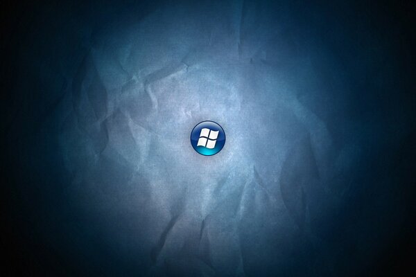Logotipo de windows en un botón azul sobre un fondo de papel arrugado