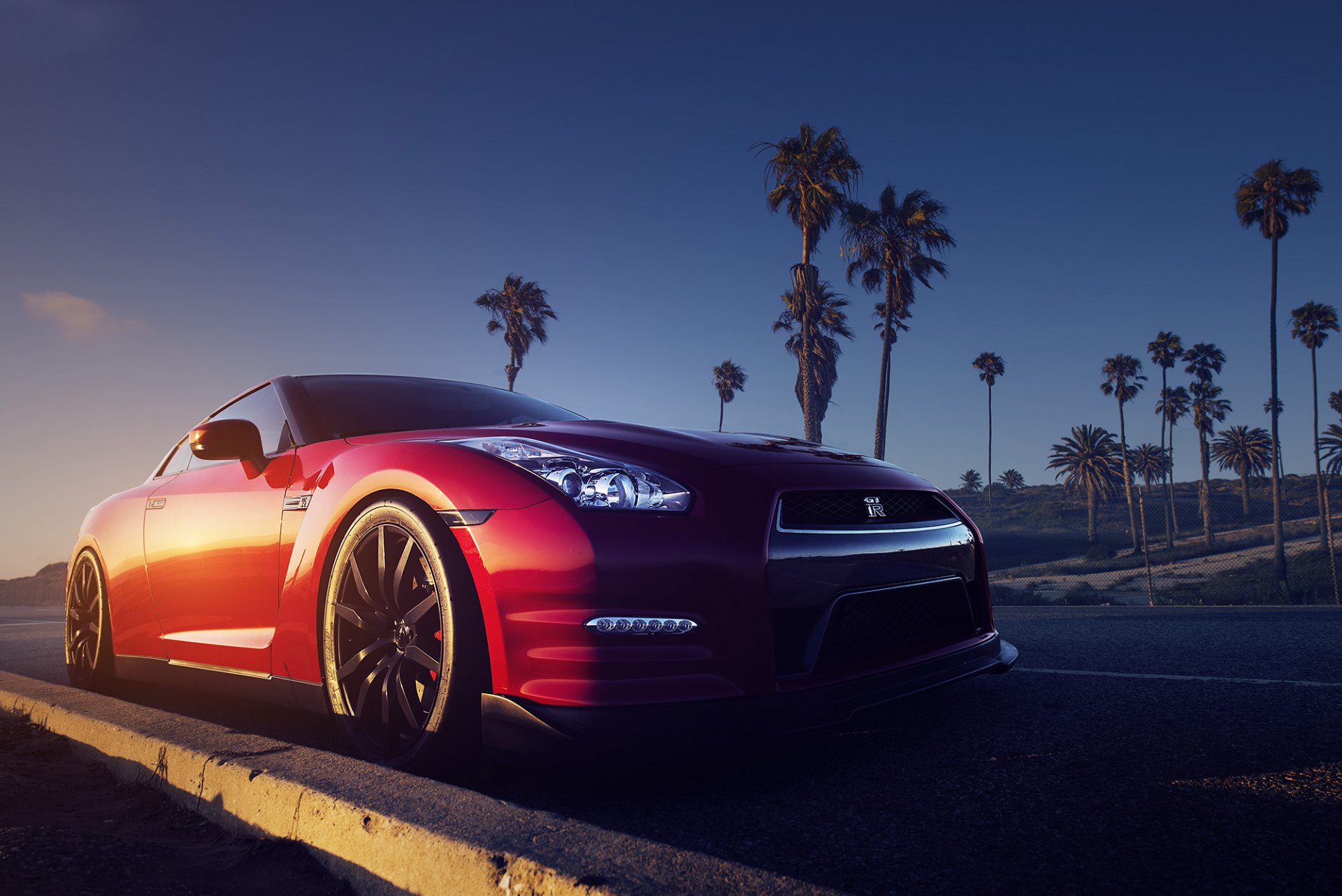 nissan gt-r r35 rojo frente carretera palmeras puesta de sol