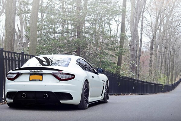 Blanco Maserati Italia en el fondo de la valla