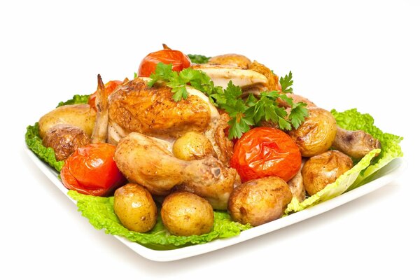Patatas, pollo y tomates en un plato