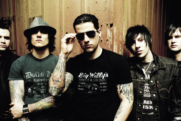 Los solistas de la banda de rock están de pie cerca de la pared
