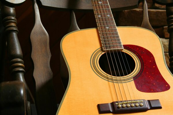 La guitarra en la silla espera en las alas