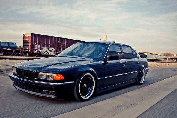 Bmw 740i azul en camino a la estación de tren