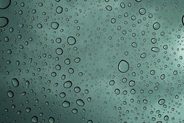 Gotas de agua en el vidrio de color verde