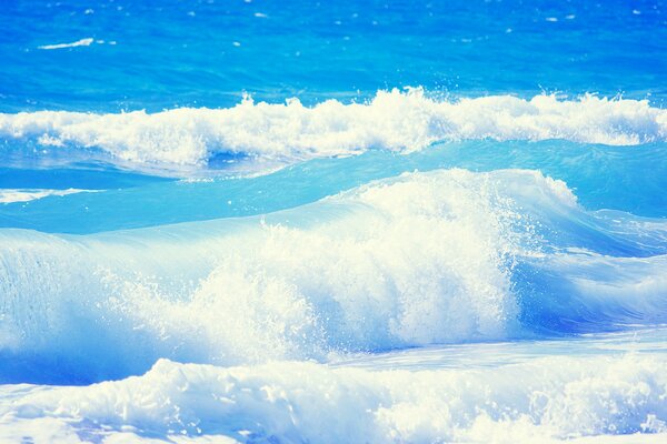 Las olas del océano azul se estrellan contra la costa