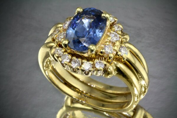 Anillo de oro con piedra azul grande y diamantes sueltos