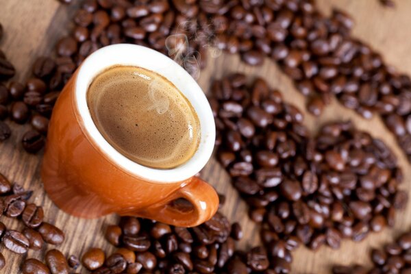 Taza de café caliente con fondo de corazón de granos de café
