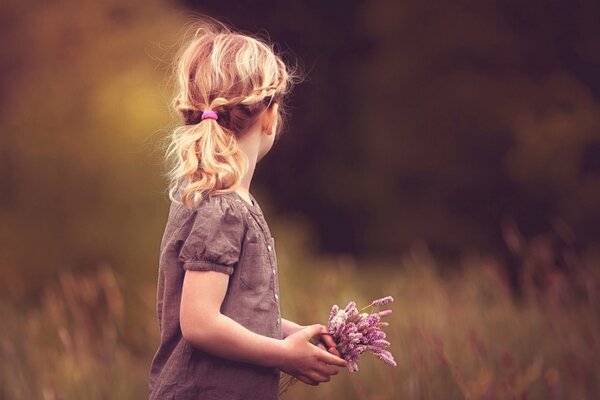 Foto de una niña con flores en medio del bosque