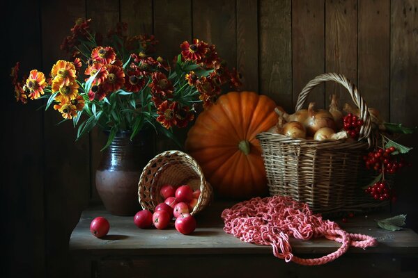 Imagen de otoño donde hay manzanas y calabazas