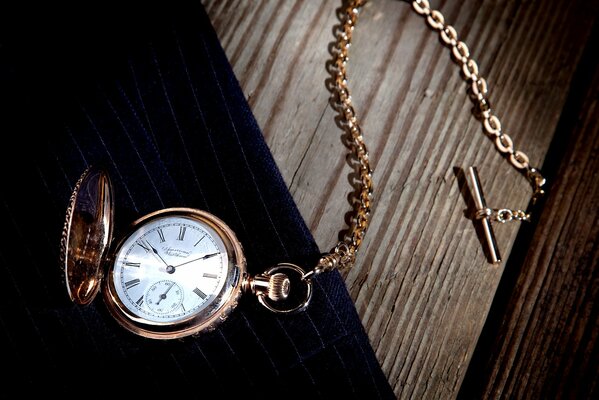 Reloj de bolsillo Vintage con cadena en la mesa