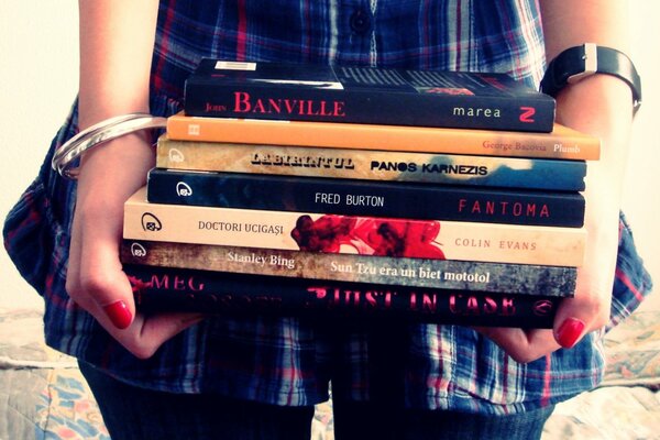 La chica tiene en sus manos los libros de texto
