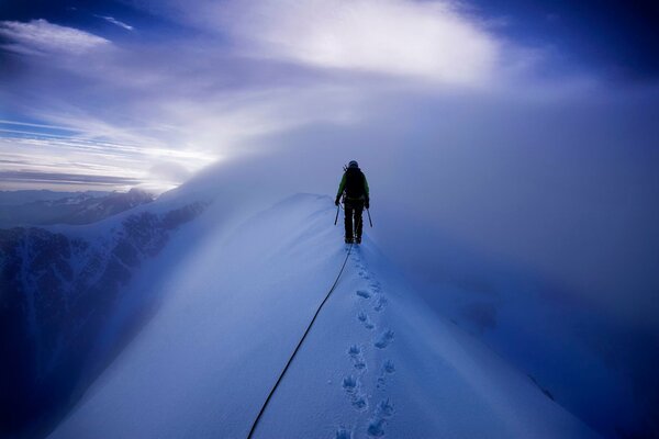 Escalador camina sobre montañas cubiertas de nieve