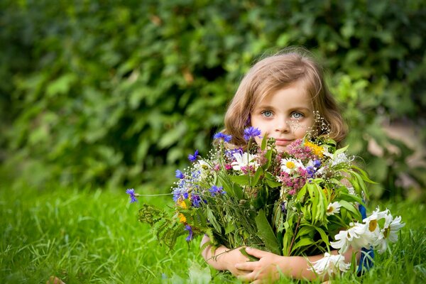 Niña recoge ramo de flores silvestres