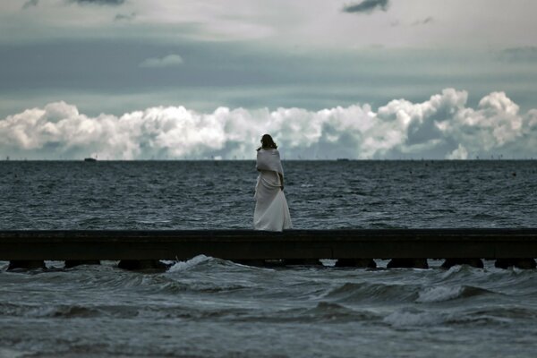 Chica mirando el mar furioso