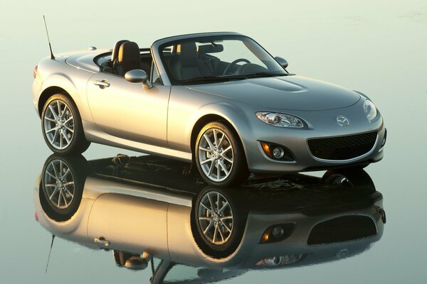 Gris Mazda en el convertible se encuentra en la superficie del espejo