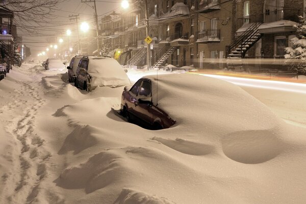 Coches bajo la nieve hermosa noche