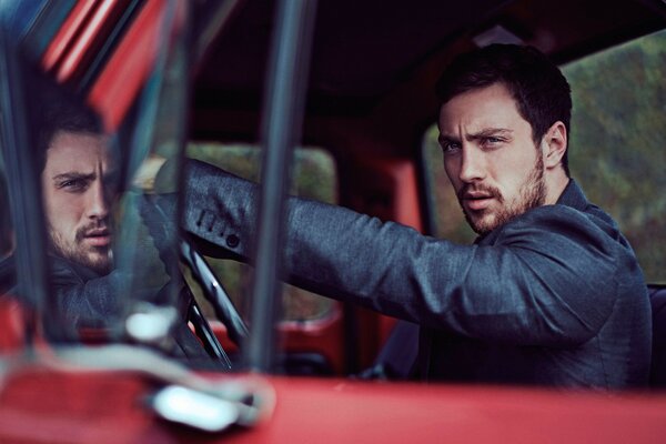 Un hombre guapo al volante de un coche
