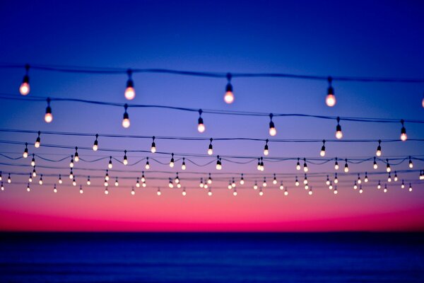 Luces encendidas en los cables en el fondo de la puesta de sol