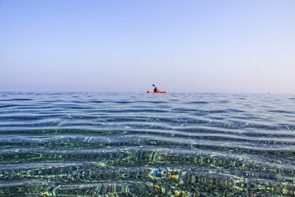 Hombre en Canoa nadando en el mar