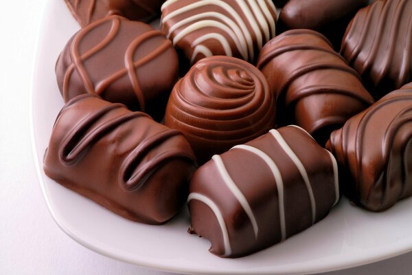Plato de dulces de chocolate sobre fondo blanco