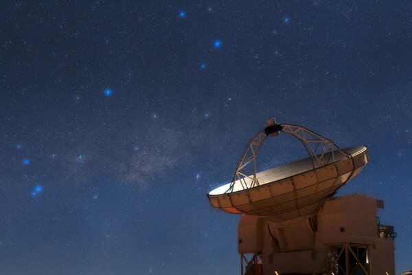 Radiotelescopio en el fondo de las constelaciones en el cielo nocturno
