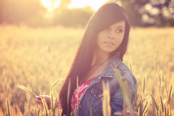 Morena en el campo. Espigas de trigo al atardecer