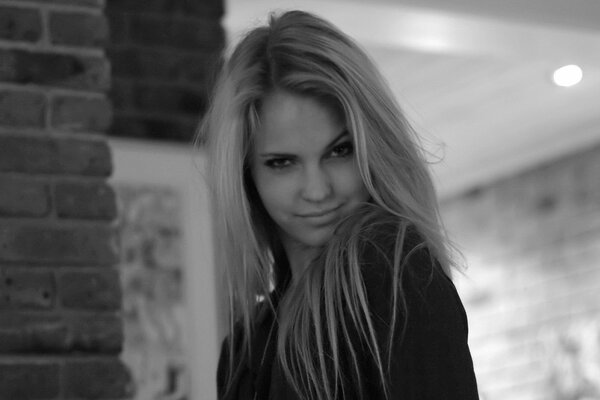 Foto en blanco y negro de la modelo Emily Marie. En la foto, una chica linda entrecerró los ojos