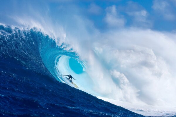 Surfista pasa bajo una gran ola