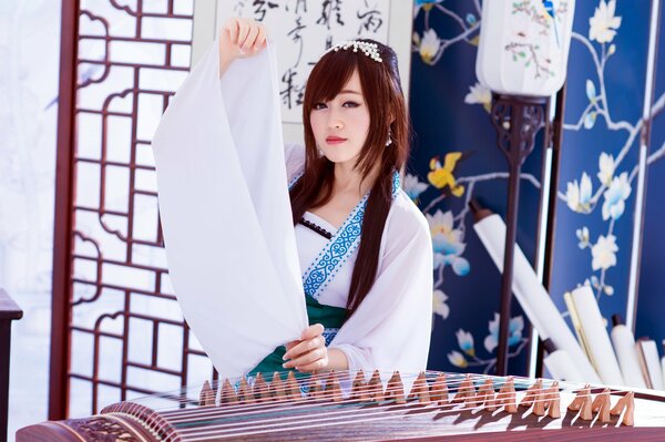 Chica asiática en blanco con un instrumento musical