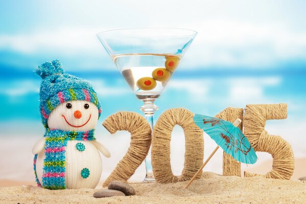 Figuras 2015 en la playa rodeada de un muñeco de nieve y una Copa de Martini con una sombrilla
