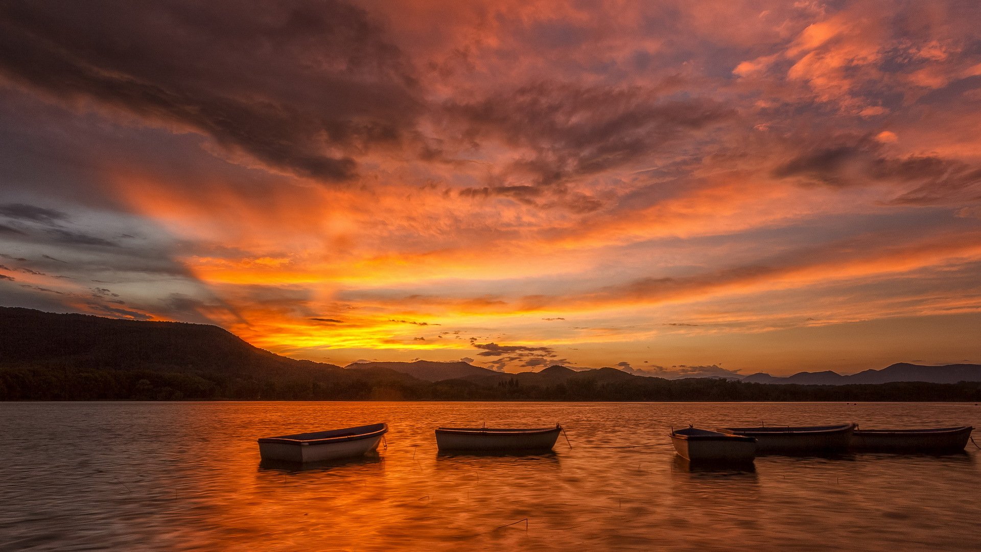 puesta de sol lago barcos