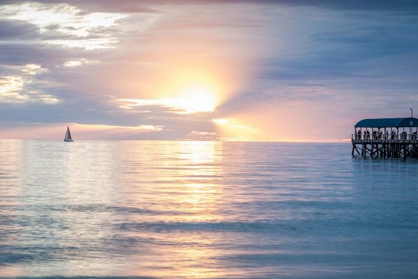 Puesta de sol en el océano con muelle