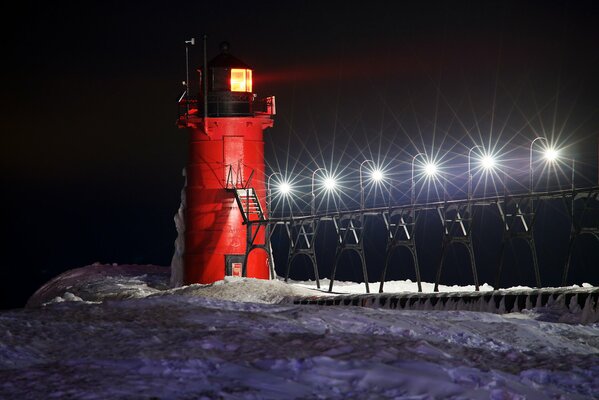 Faro nocturno entre la nieve en invierno