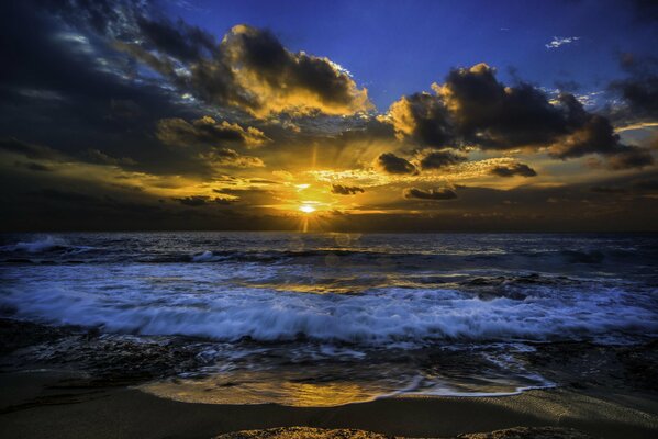 El sol se abre paso a través de las nubes sobre el océano