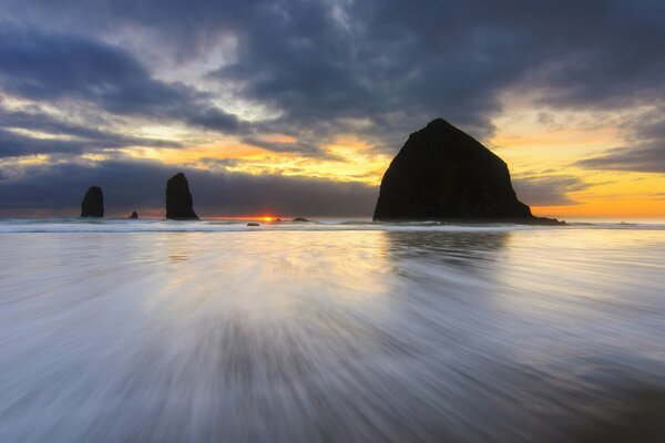 Puesta de sol en una playa en los Estados Unidos. Rocas en Oregon